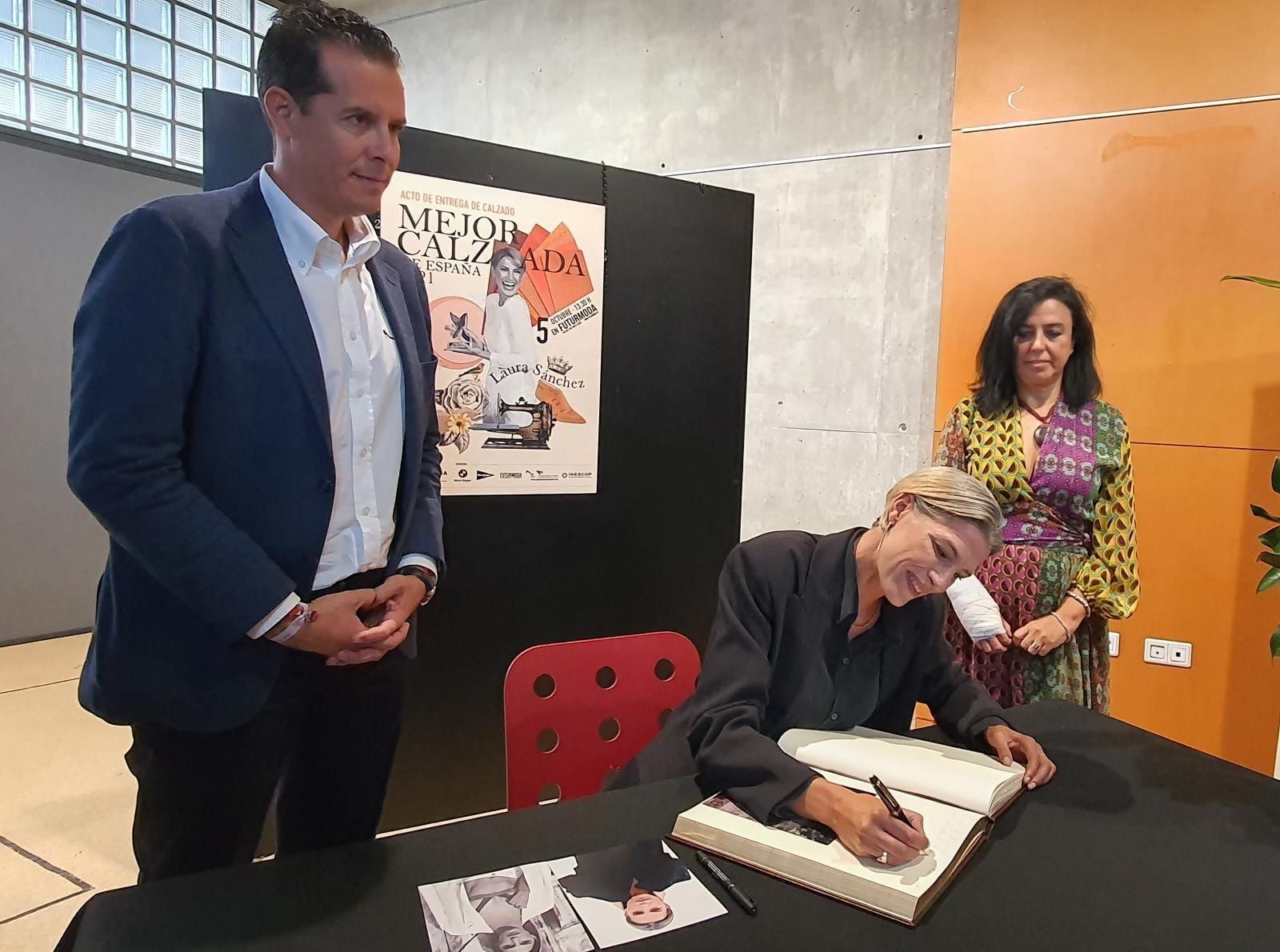 La modelo Laura Sánchez firmando en el libro de honor del Museo del Calzado en presencia de su directora, Loles Esteve, y del alcalde Rubén Alfaro.