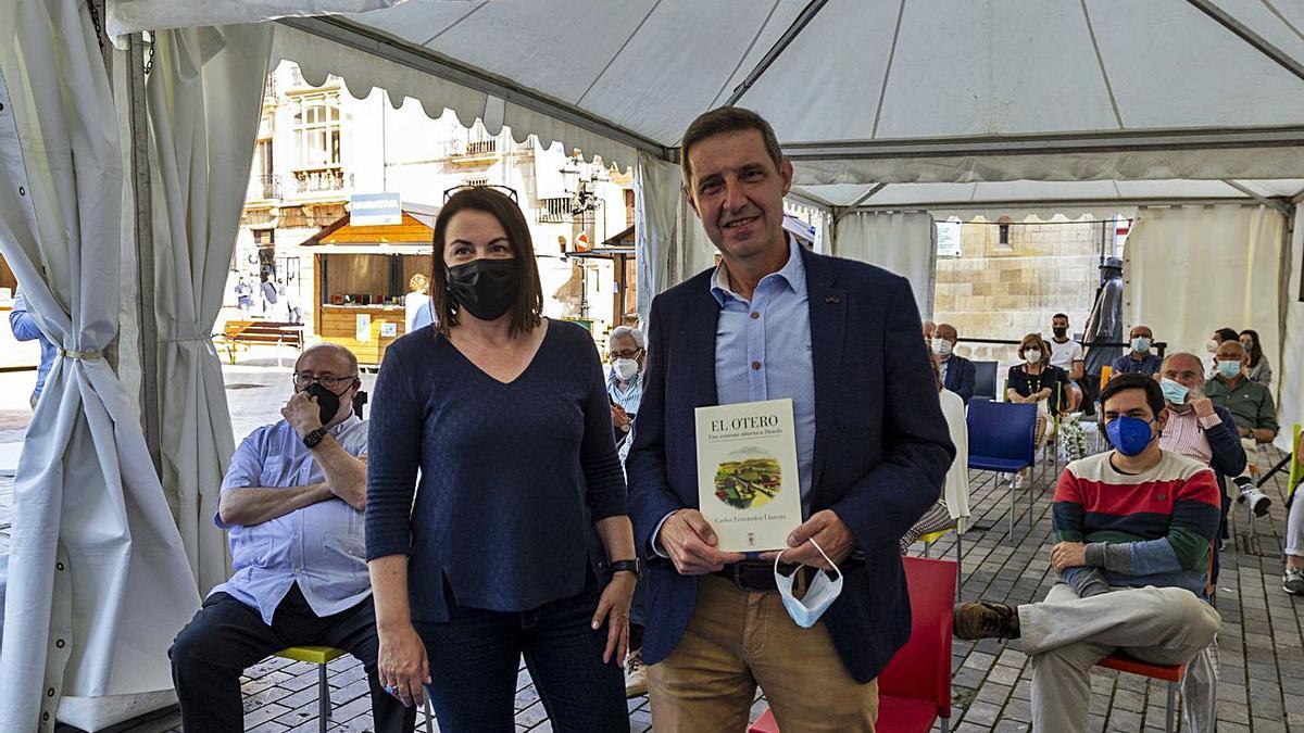 Carlos Fernández Llaneza, con su libro, junto a Ángeles Rivero, en LibrOviedo. | Nazaret Quintas