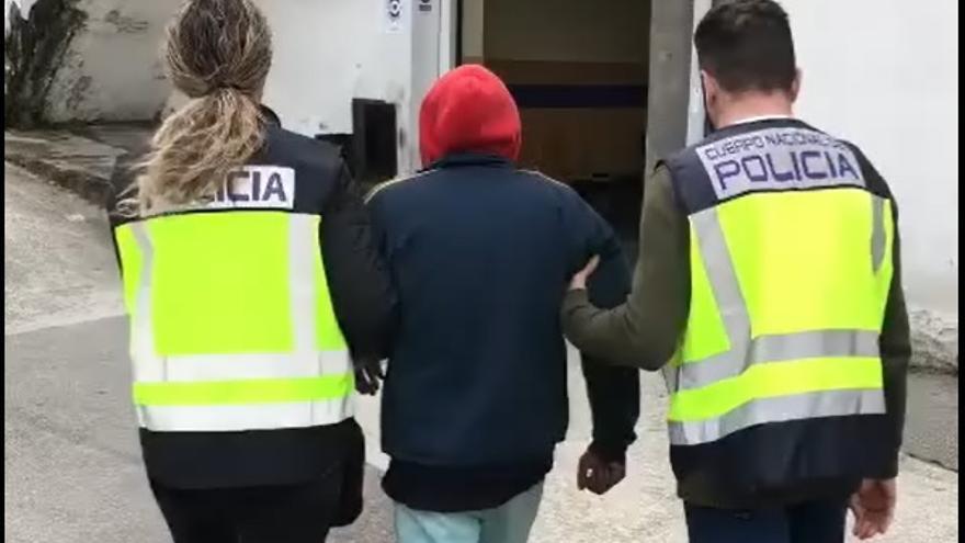 Dos agentes conducen al detenido durante el arresto.