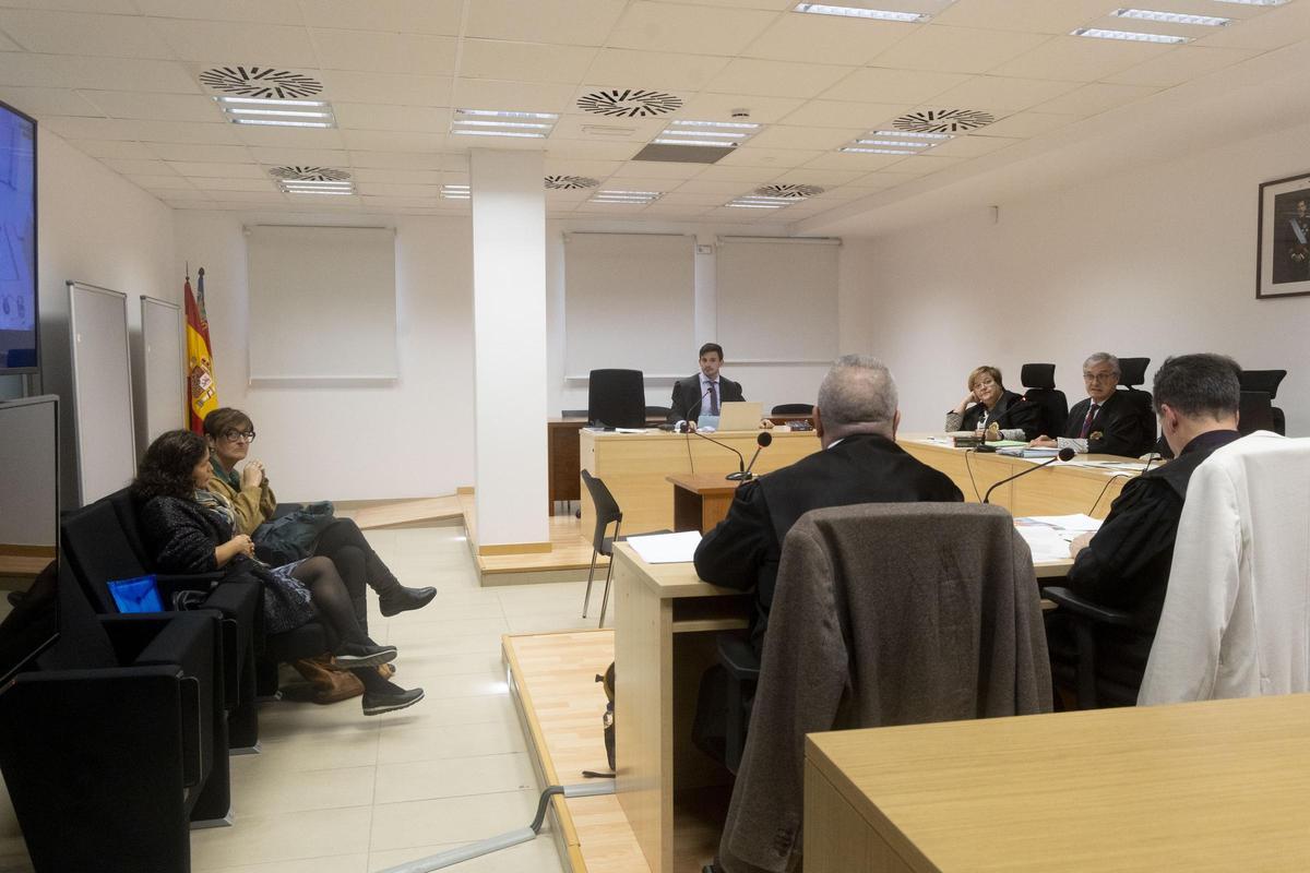 La acusada sentada en el banquillo con la intérprete a su izquierda, antes del juicio.