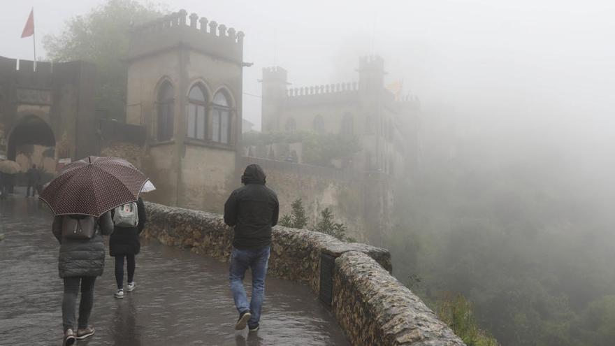 Un grupo de visitantes accede al castillo de Xàtiva, envuelto en la niebla