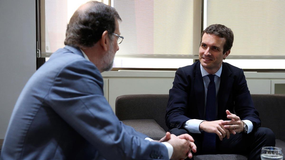 El nuevo presidente del Partido Popular, Pablo Casado, y el presidente del PP saliente, Mariano Rajoy, durante la reunión en la sede nacional del partido tras la celebración del Congreso Nacional Extraordinario del PP