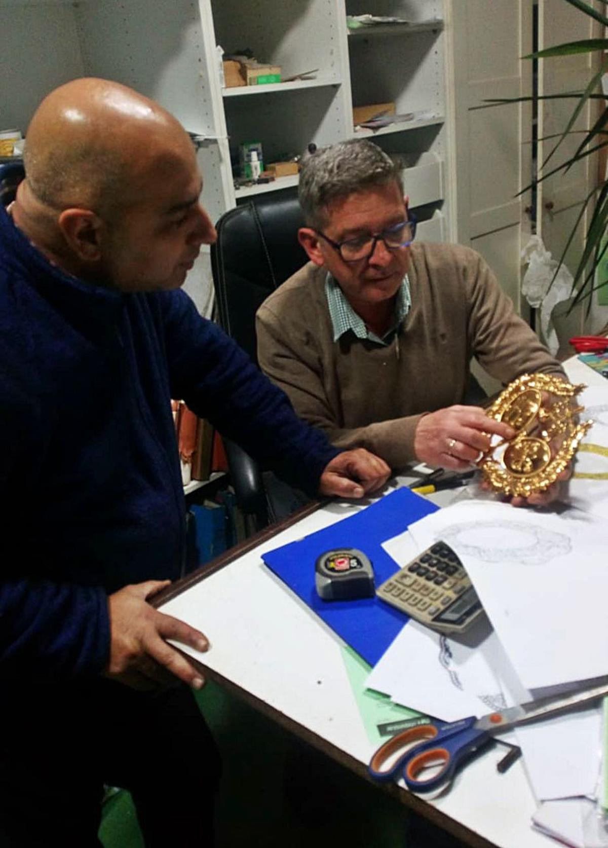 Los orfebres Rafael González y Paco Villarreal, examinando el escudo de los Estudiantes, labrado en oro, en su taller de Sevilla, en una imagen de archivo.
