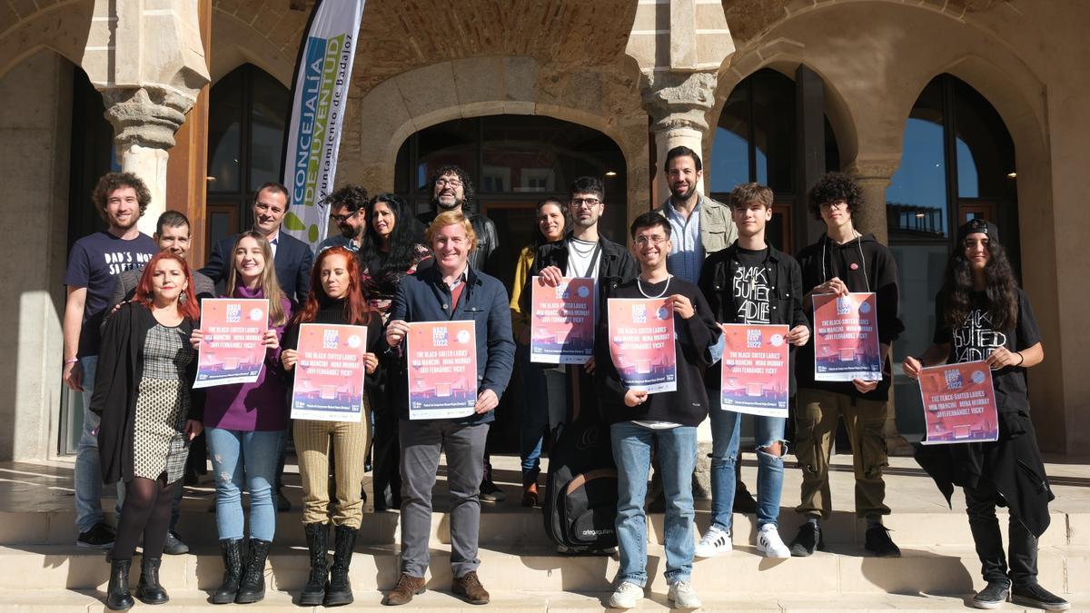 Autoridades y los grupos seleccionados posan con el cartel del tercer Badafest.