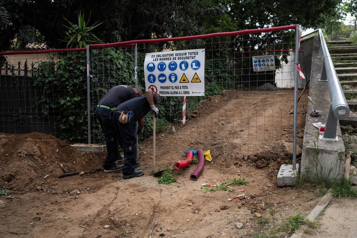 Dos trabajadores en la zona de obras del parque del Castell de l'Oreneta, en el barrio de Sarrià, en Barcelona.