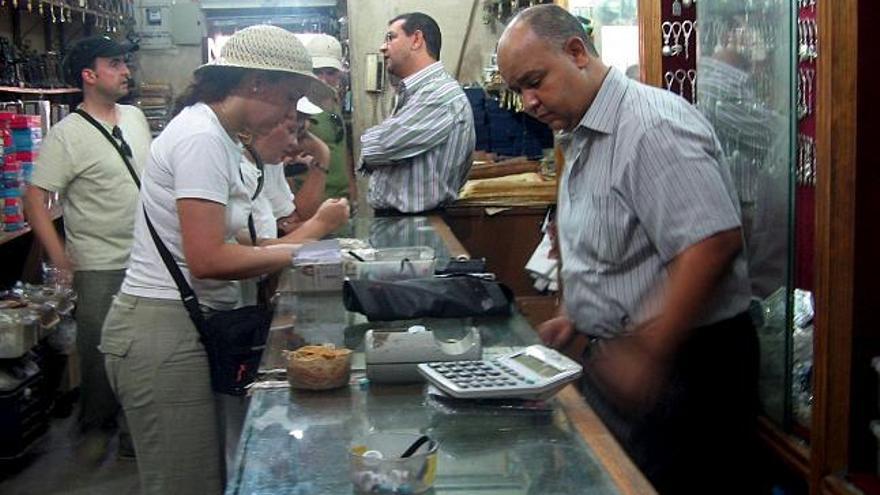 Varios turistas compran algun objeto en la tienda de recuerdos de &quot;Jordi!&quot;, en el mercado de Jan Al Jalili, en el barrio islámico de El Cairo, lugar donde acuden los turistas españoles que visitan la capital egipcia. La crisis económica en España se ha dejado notar hasta en el gran bazar de El Cairo, conocido como Jan al Jalili, donde los turistas españoles que llegan cada vez se gastan menos dinero. EFE/Susana Samhan