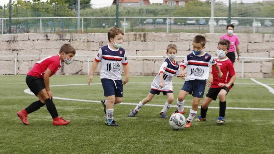 Varios jugadores del Victoria y Arenas sub 7 pelean por un balón.