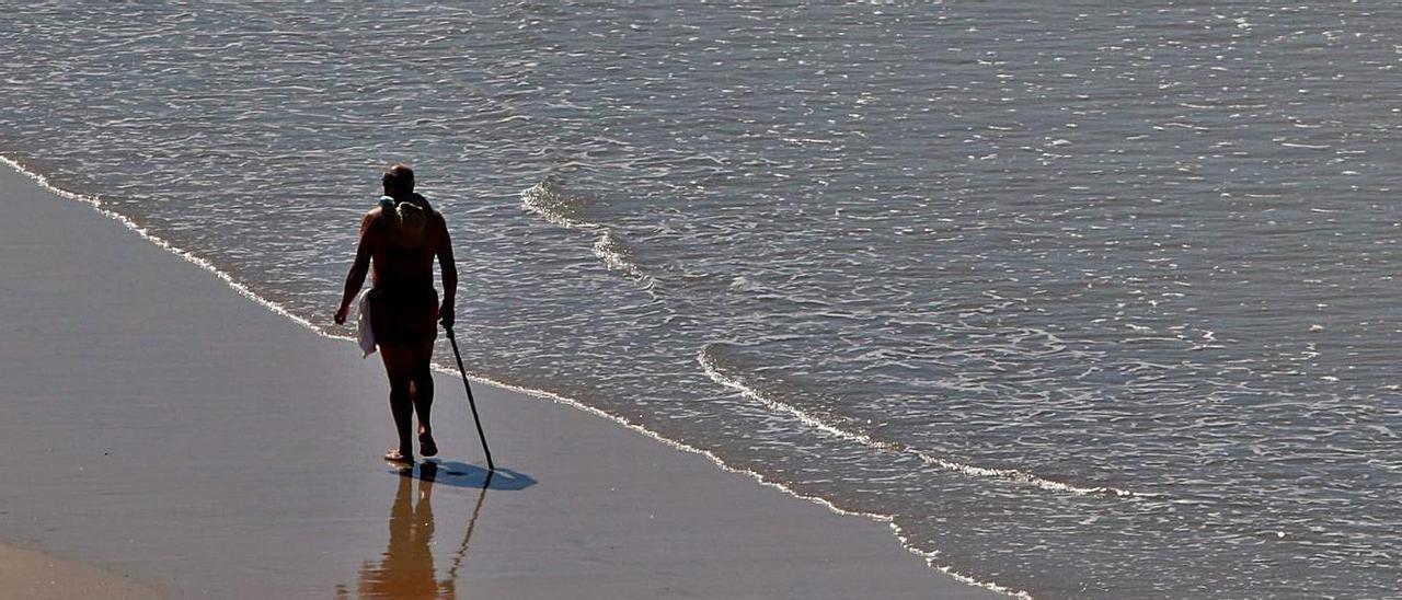 Un hombre pasea por la playa de A Lanzada