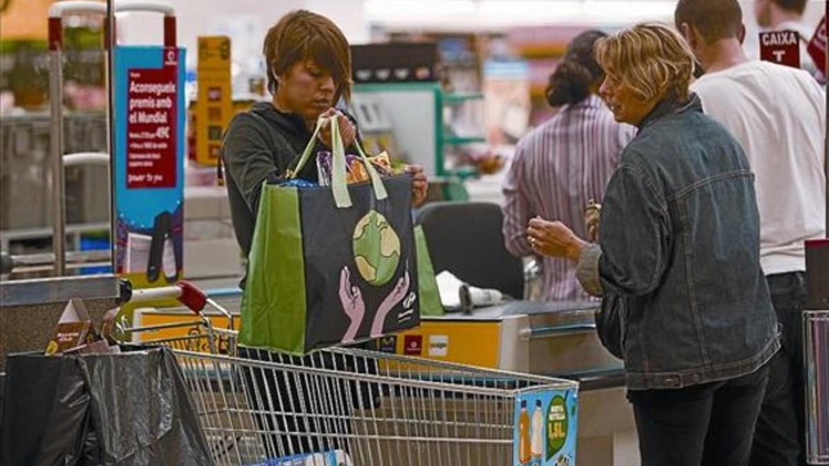 Una clienta se lleva la compra en una bolsa reutilizable, ayer en un hipermercado de Barcelona.