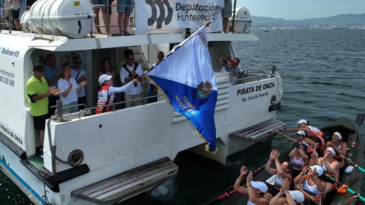 La trainera femenina recibe la bandera.