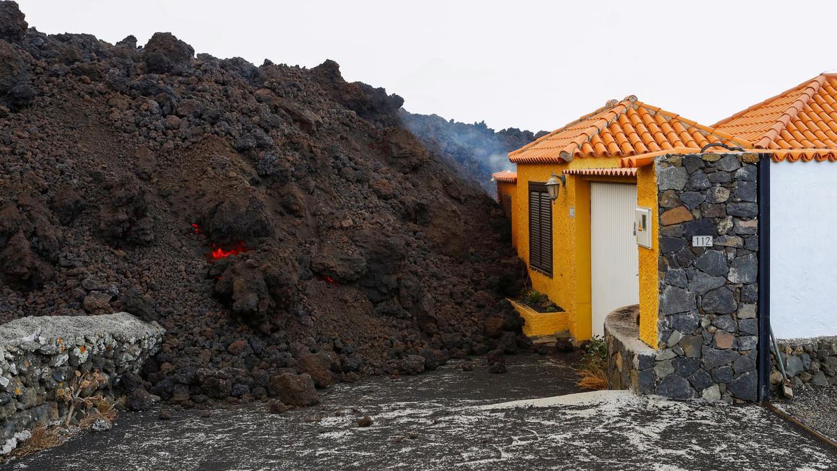 Lava reaches a house following the eruption of a volcano in Spain