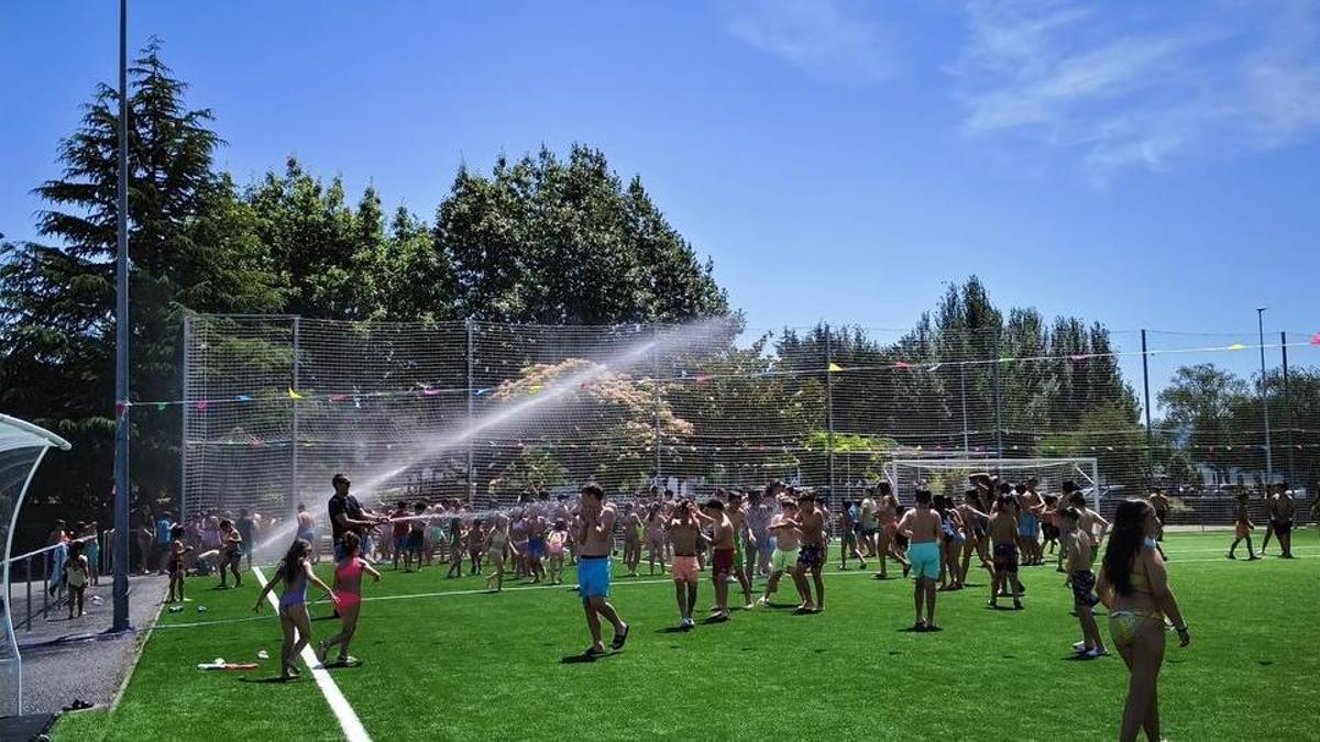 Alumnado de Reibón en Moaña se refresca con una manguera en el campo del keniata.