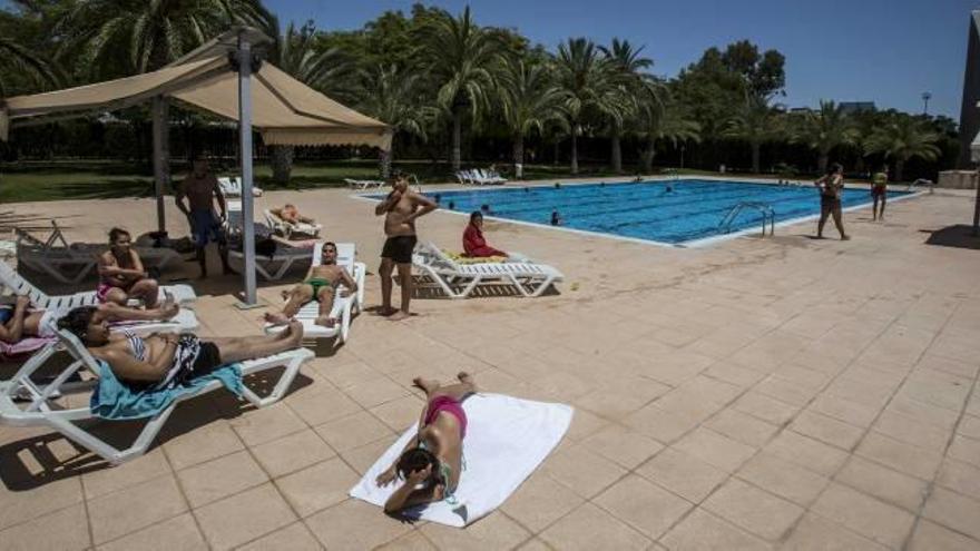 Un grupo de jóvenes disfruta del sol en el primer día de verano de piscinas descubiertas.