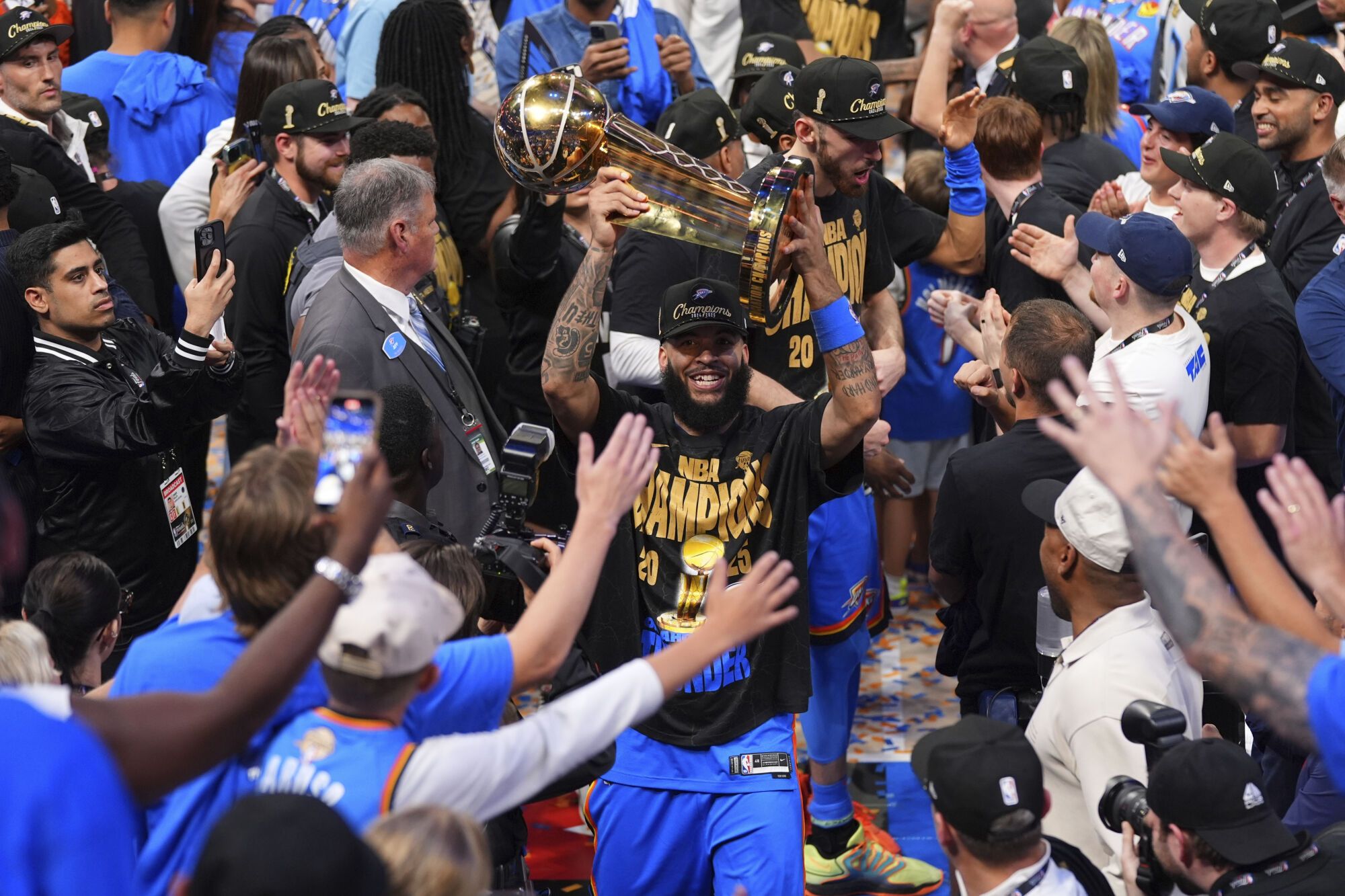 Oklahoma City Thunder forward Kenrich Williams holds up the Larry O'Brien Championship Trophy as he celebrates with his team after they won the NBA basketball championship with a Game 7 victory against the Indiana Pacers Sunday, June 22, 2025, in Oklahoma City. (AP Photo/Kyle Phillips)