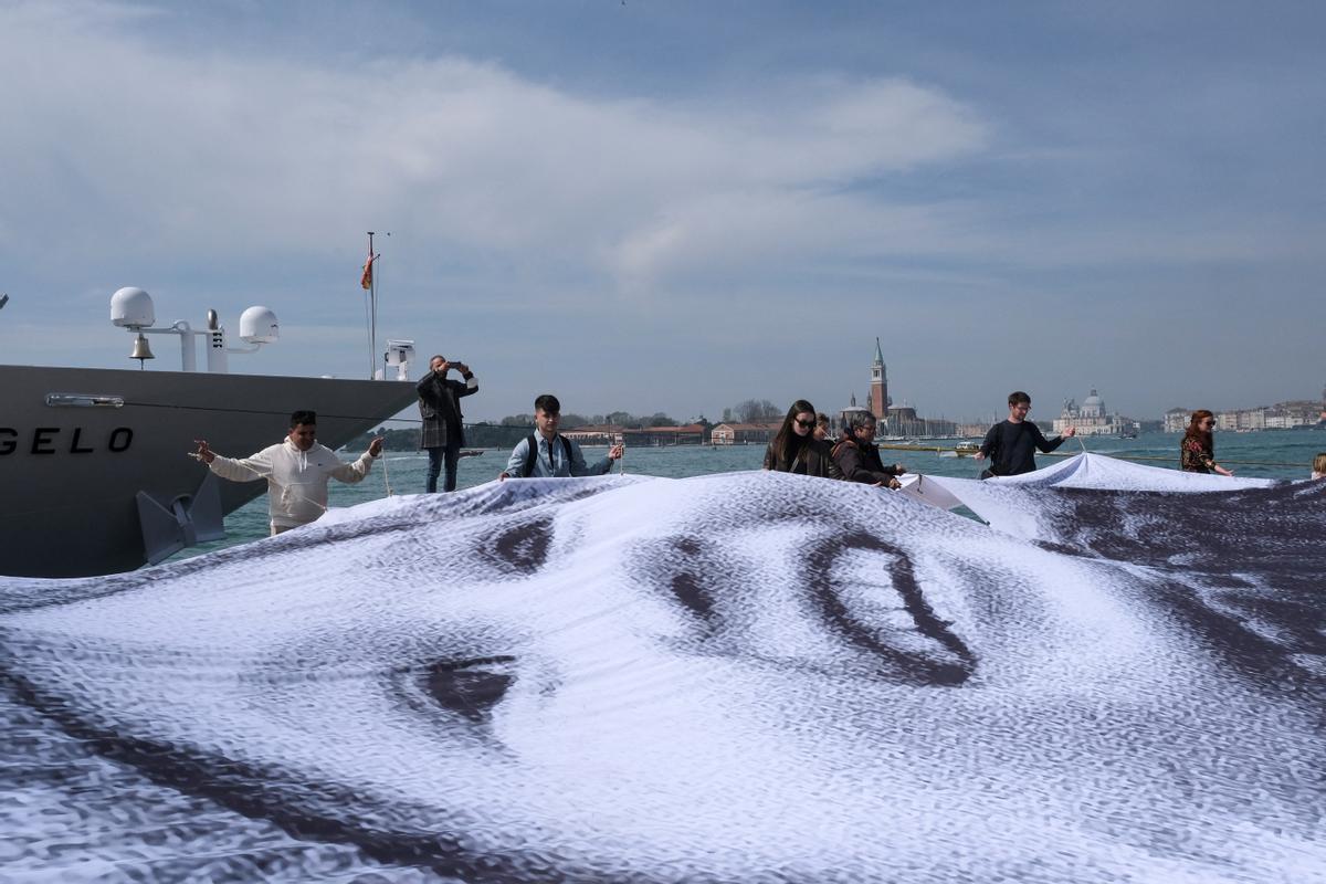 Una fotografía gigante de un joven refugiado ucraniano se revela como parte de una instalación de arte del artista contemporáneo francés JR para mostrar su solidaridad con Ucrania en medio de la invasión de Rusia, en Venecia, Italia.