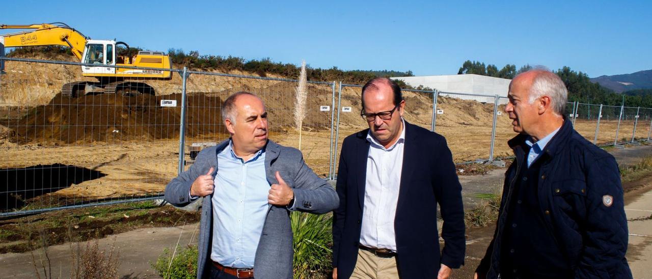 Javier Tourís, Javier Domínguez y Gonzalo Durán ante una excavadora trabajando en los terrenos que ocupará Sogama en Baión.