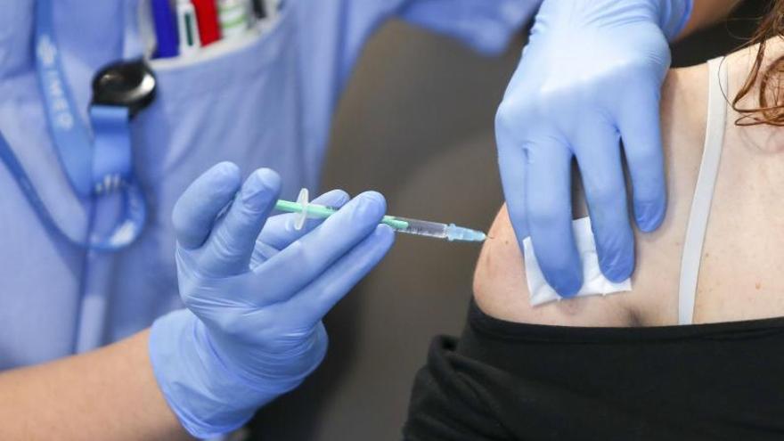 Una enfermera del hospital IMED de Burjassot vacuna a una trabajadora de segunda línea del centro sanitario, la semana pasada. | F. CALABUIG