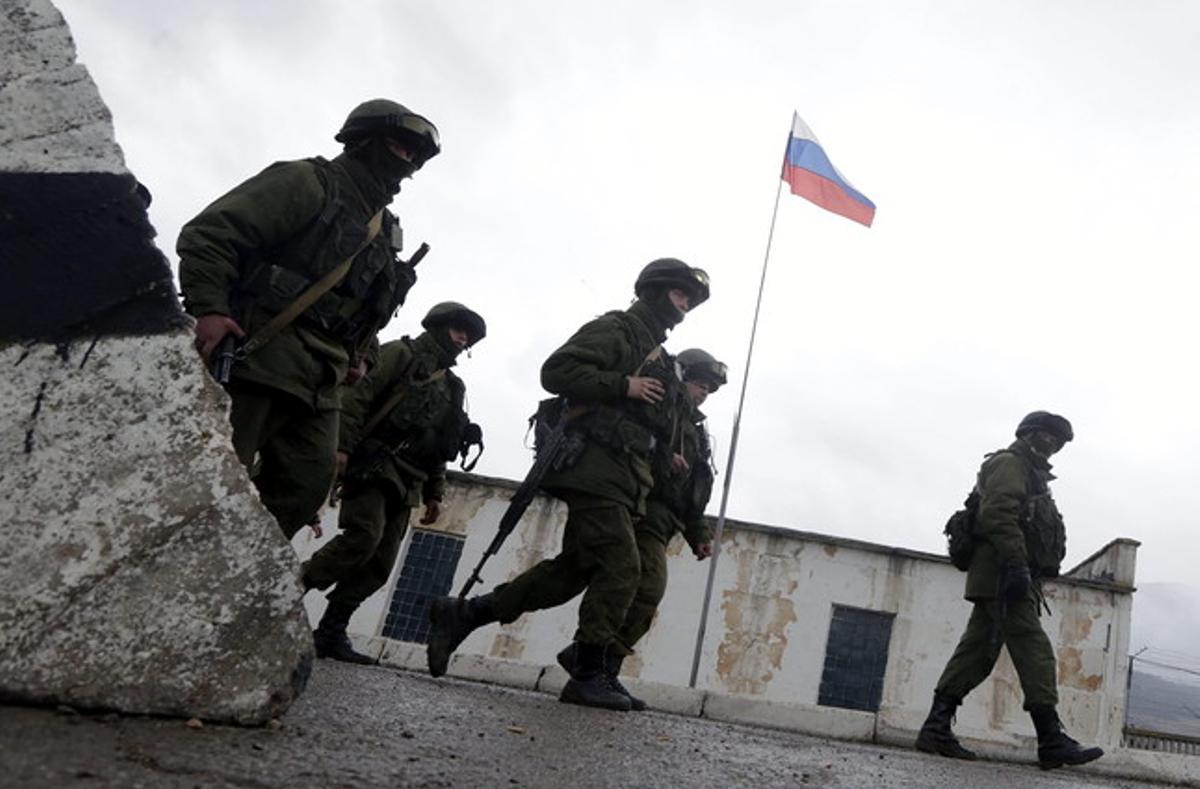 Un grup de soldats armats caminen a prop d’un accés a la base militar situada a la localitat de Perevalnoie, als voltants de Simferópol, a la península ucraïnesa de Crimea, el passat dia 7.