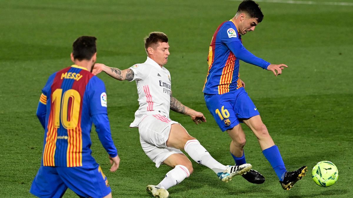 Pedri intenta eludir la entrada de Kroos en el clásico de Valdebebas.