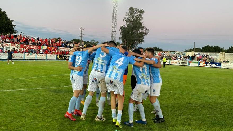 Los jugadores del Coria festejan el ascenso en el centro del campo.