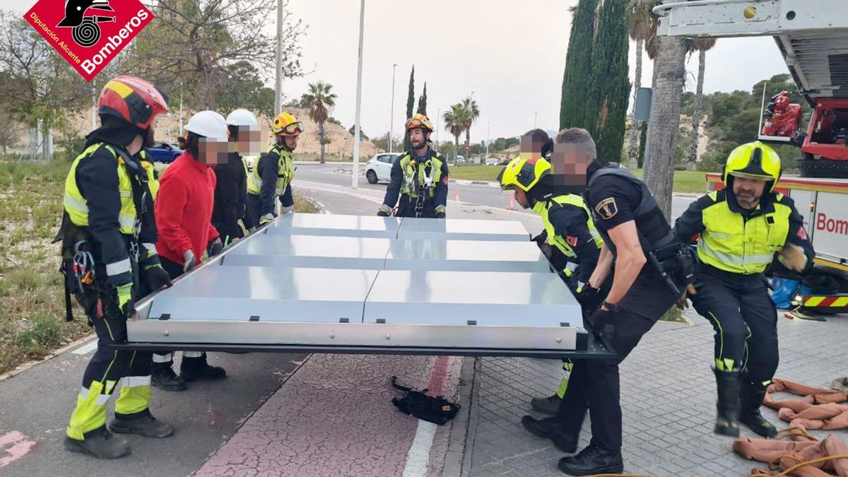Bomberos y Policía Local retirando el cartel de la avenida de Benidorm.