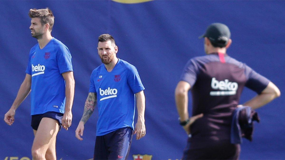 Leo Messi, entre Gerard Piqué y Ernesto Valverde durante un entrenamiento del Barça