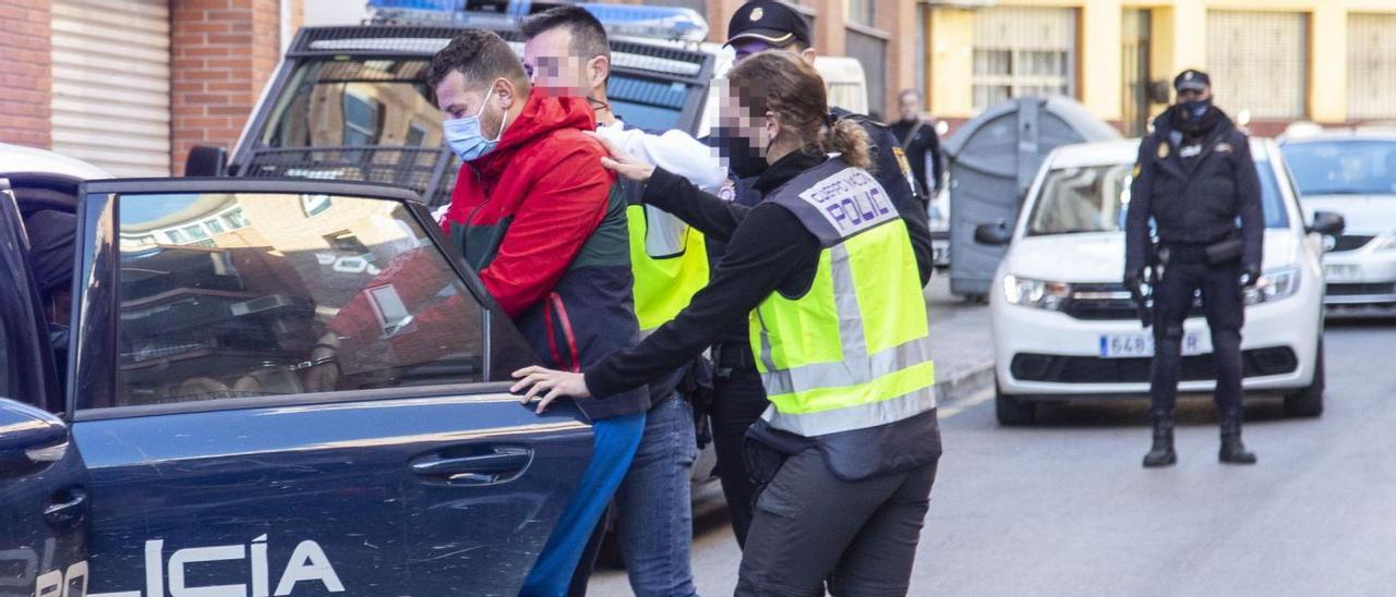 Agentes de la UCRIF introducen en un vehículo de la Policía a uno de los detenidos por la red de inmigración y tráfico de drogas. | ALEX DOMÍNGUEZ