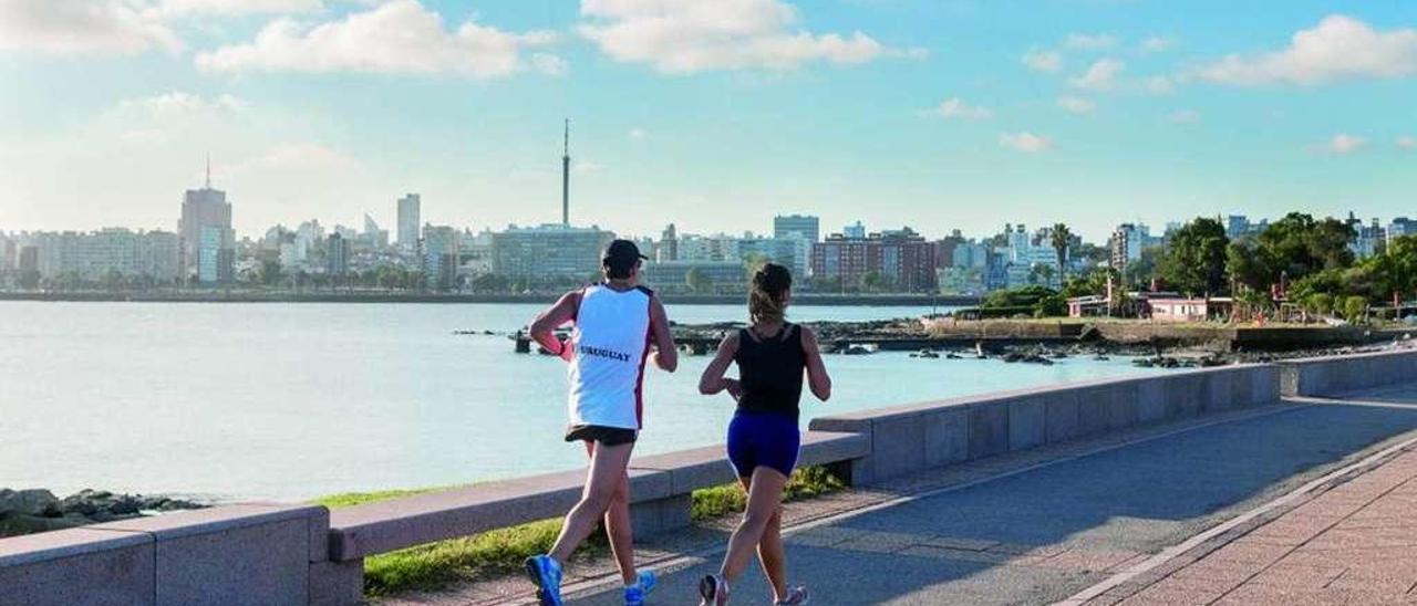 Una pareja de uruguayos corre por el paseo marítimo de Montevideo. // Leo Correa