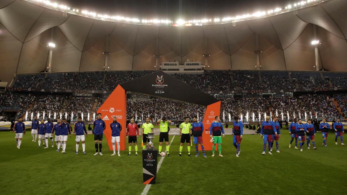 Los jugadores del Real Madrid (i) y del FC Barcelona (d), al comienzo del encuentro correspondiente a la semifinal de la Supercopa de España que han disputado hoy miércoles en el estadio Ray Fahd de Riad.