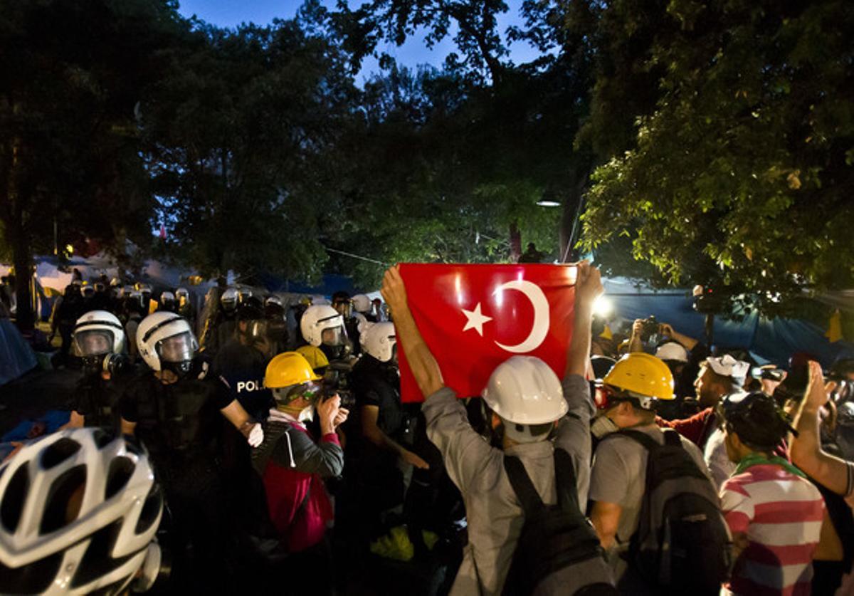 Manifestants resisteixen l’avanç de la policia al parc Gezi d’Istanbul, diumenge a la matinada.