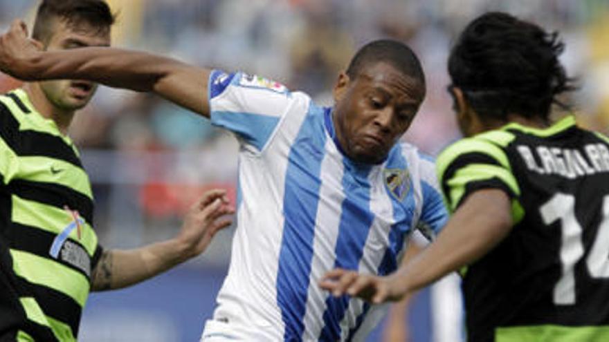 El delantero hispano-brasileño del Málaga CF Julio Baptista (c) conduce el balón presionado por los mediocentros del Hércules CF Tiago Gomes (i) y Abel Aguilar durante el encuentro, correspondiente a la trigésima cuarta jornada del Campeonato Nacional de Liga de Primera División, que enfrenta a ambos equipos esta tarde en el estadio de La Rosaleda.