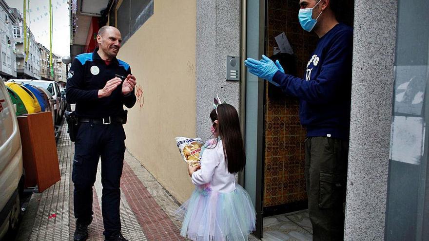 Pedro Esmorís, policía en Arteixo, regala una bolsa de patatas fritas a una niña por su cumpleaños.