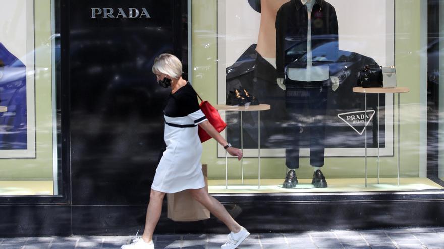 Una dona passa amb mascareta per davant d&#039;una botiga de Prada a Brussel·les, Bèlgica