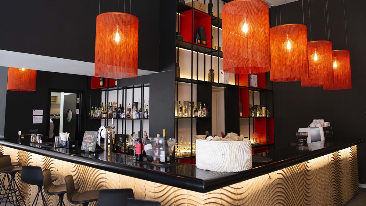 El lounge bar del hotel en Oporto, con iluminación cálida y un diseño contemporáneo pensado para prolongar la noche.