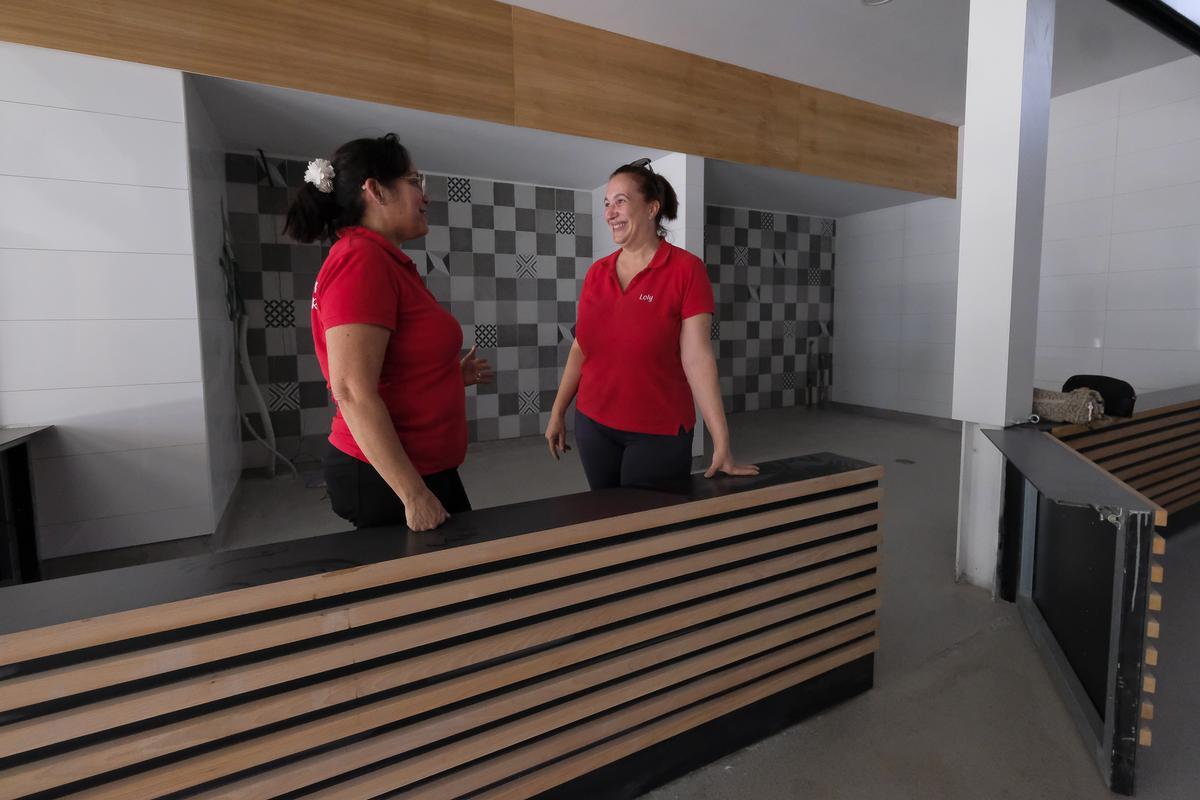 Dos comerciantes en uno de los renovados puestos del Mercado Municipal, el verano pasado.