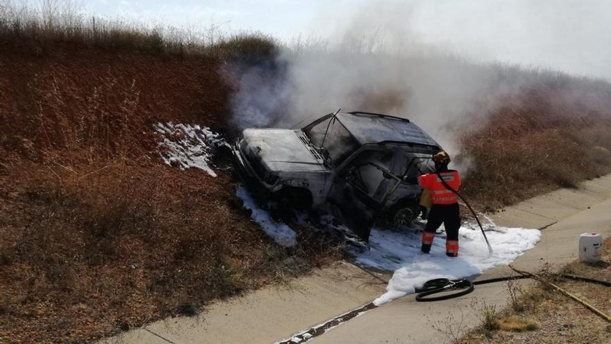 Bomberos sofocan las llamas del vehículo siniestrado.