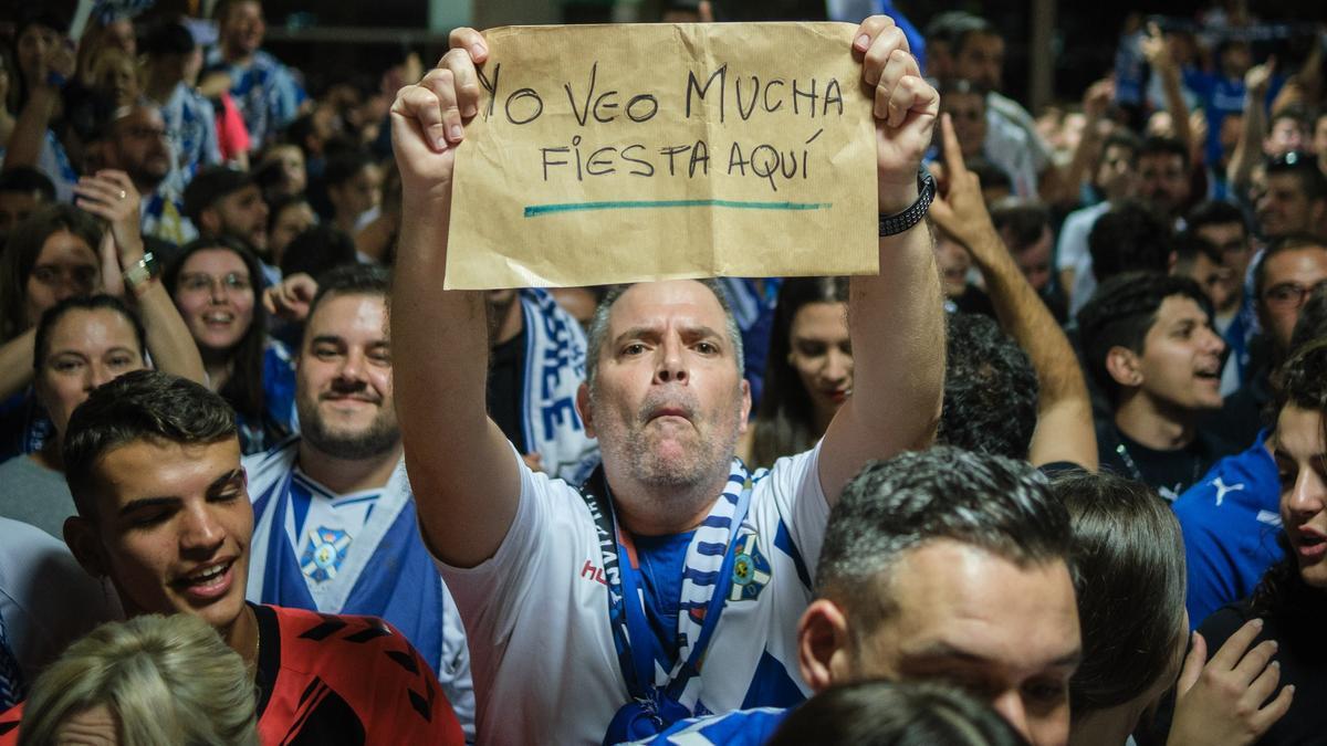 Un aficionado del Tenerife, a la llegada de la expedición blanquiazul, en Tenerife Norte, tras eliminar a la UD.