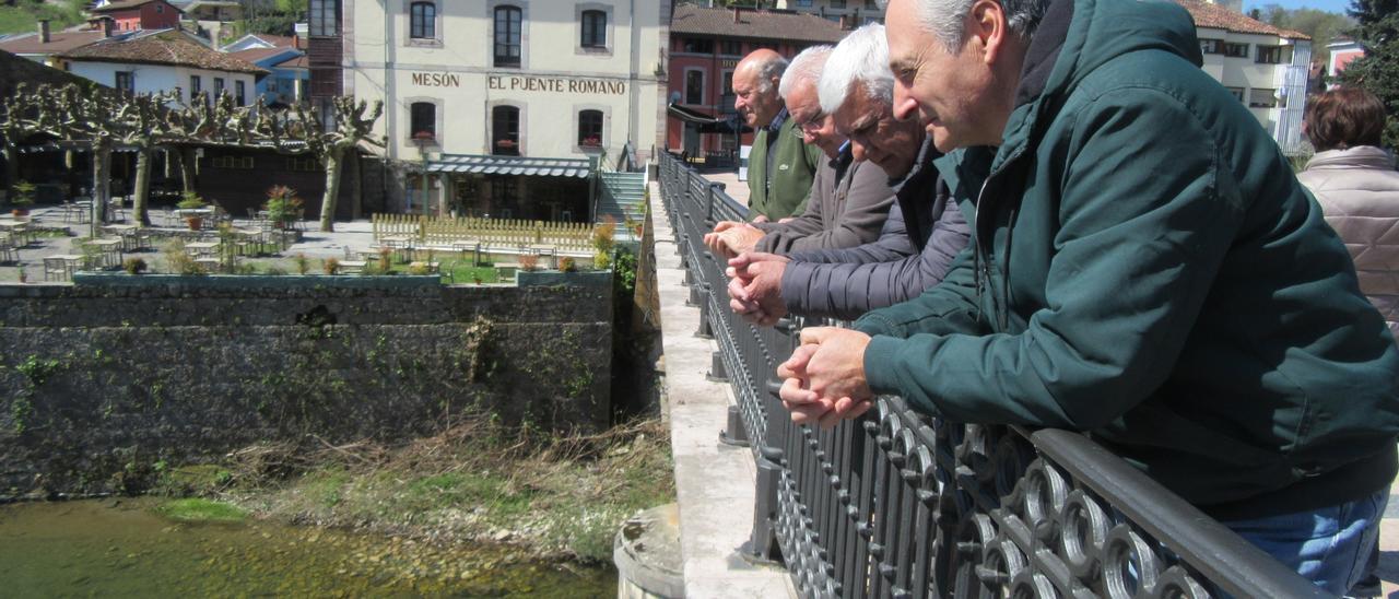 Arriba, los ribereños José Ramón Lanza, Ángel Fernández “Canalón” (tapado), Óscar Escandón y David Hórreo, este sábado, observando el Sella en Cangas de Onís. | J. M. C.