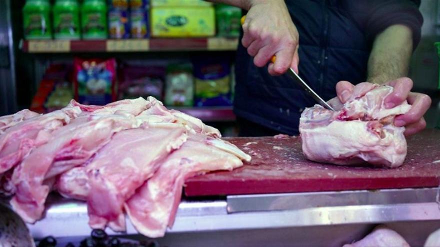 Un dependent filant carn en un supermercat