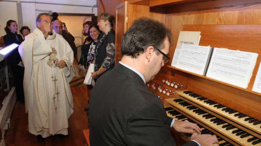 El párroco de San Jaime y Santa Ana bendice el órgano, ayer por la mañana, en el primer acto religioso de las fiestas.