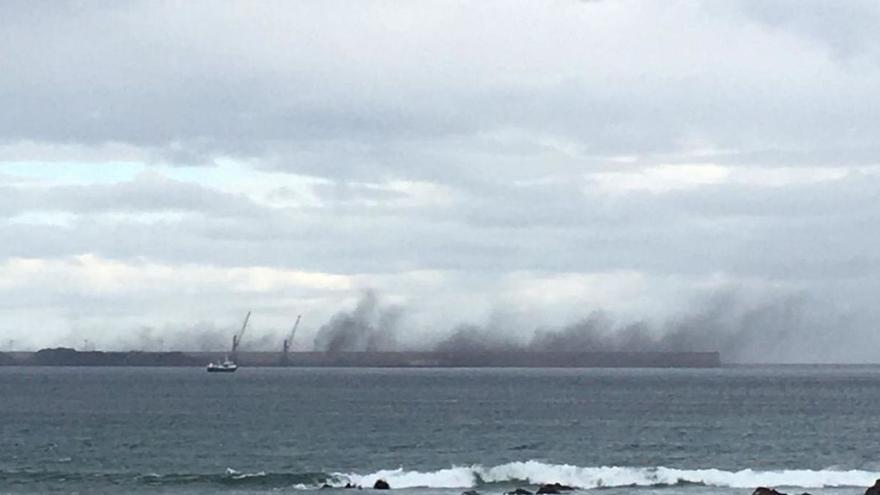 El fuerte viento levanta nubes de carbón en El Musel