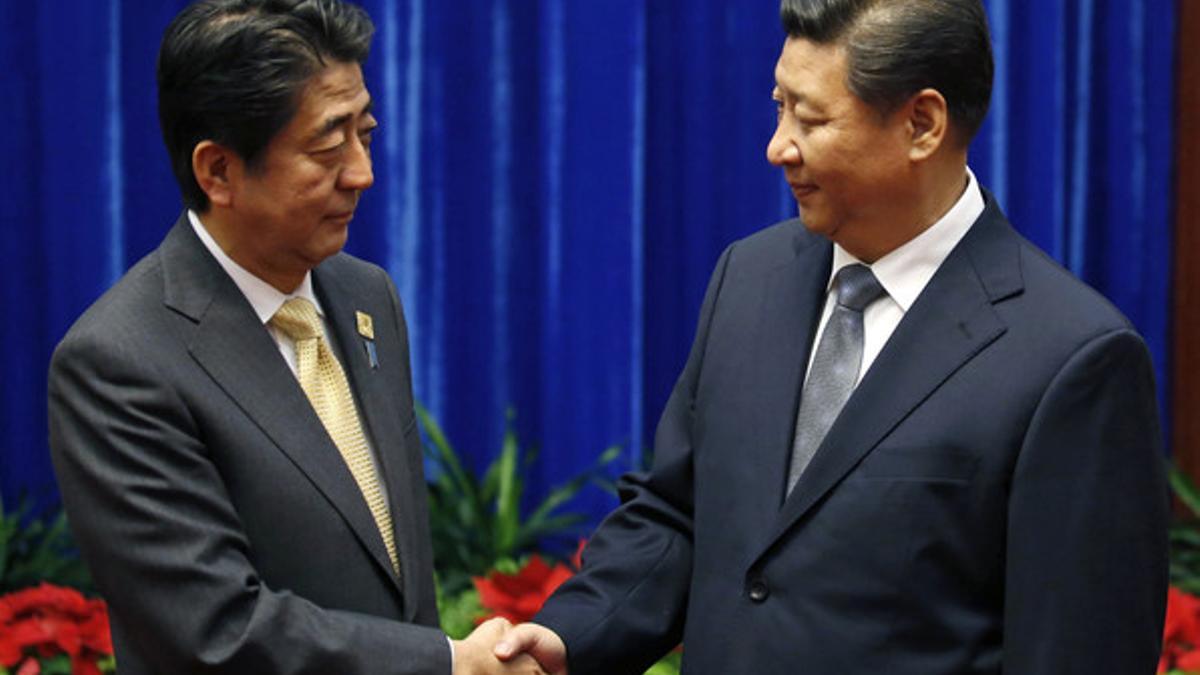 El primer ministro de Japón, Shinzo Abe (izquierda),y el presidente de China, Xi Jinping, se saludan, este lunes en Pekín.