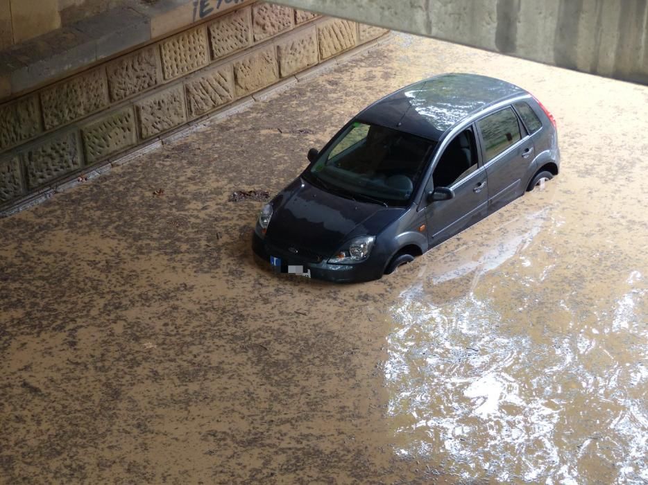 Un cotxe queda atrapat per l'aigua al passeig del Riu