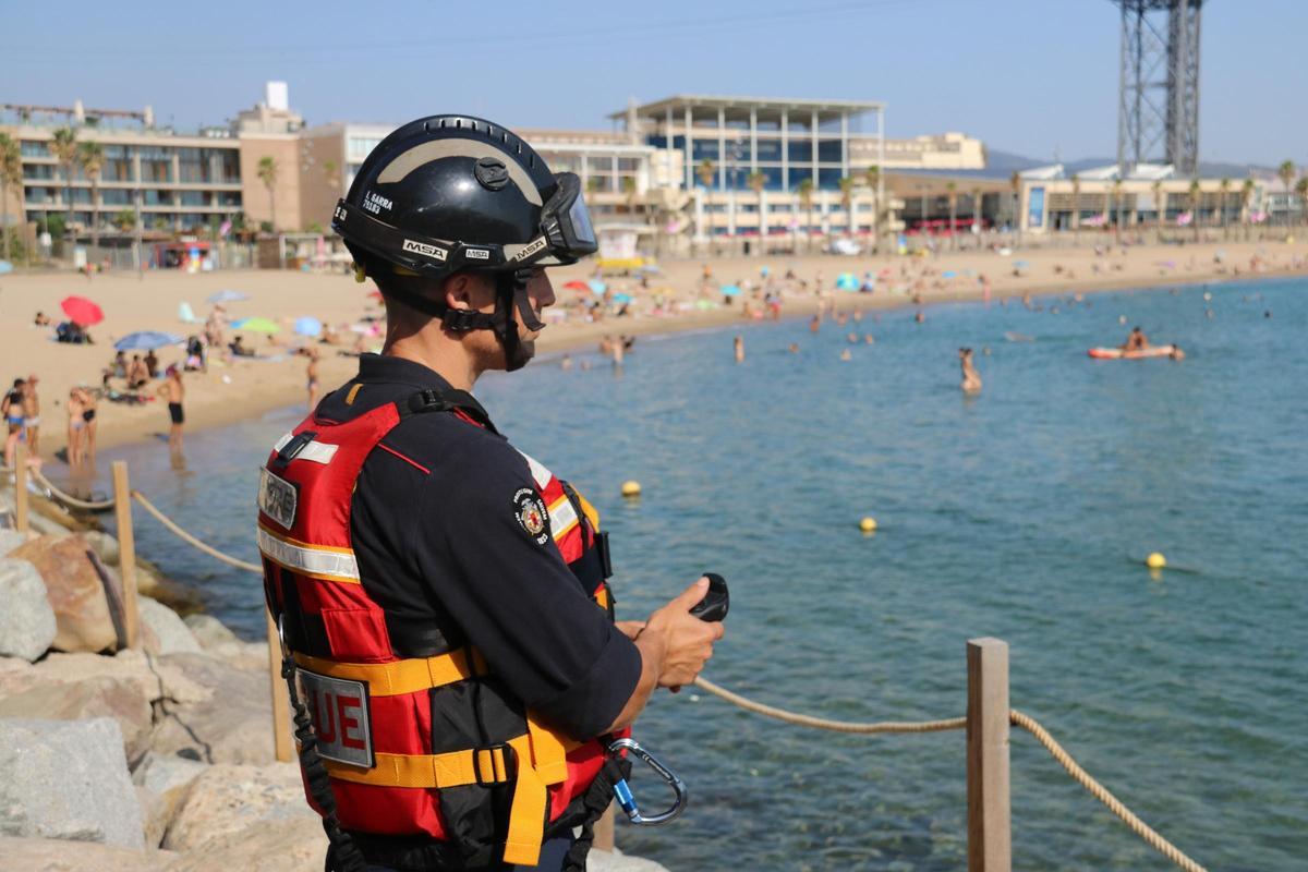Un bombero cotrola el salvavidas teledirigido en una playa de Barcelona