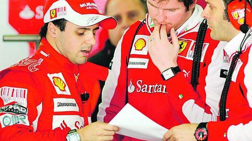 Felipe Massa cambia impresiones con sus ingenieros en el garaje de Ferrari en Montmeló.