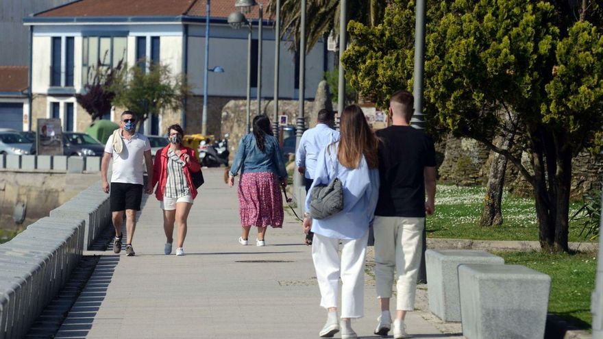 Ciudadanos caminan por el paseo marítimo de Cambados. | // NOÉ PARGA