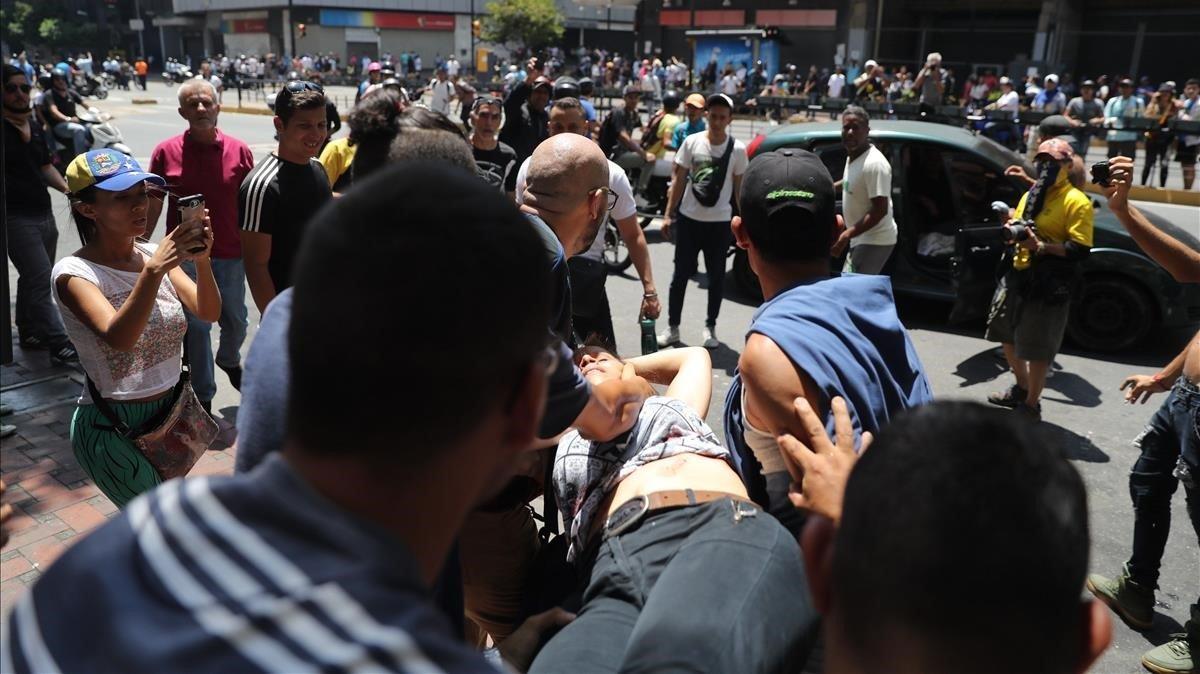 Evacuación de una mujer herida de bala en el estómago, durante una manifestación a la altura del ministerio de Transporte en la Avenida Francisco de Miranda de Caracas (Venezuela).