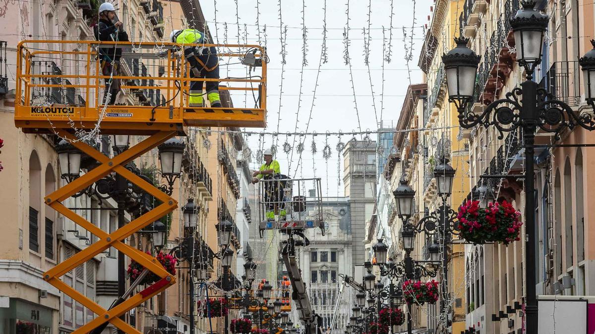 Operarios instalando el manto de luz que lucirá en la calle Alfonso hasta la plaza del Pilar.