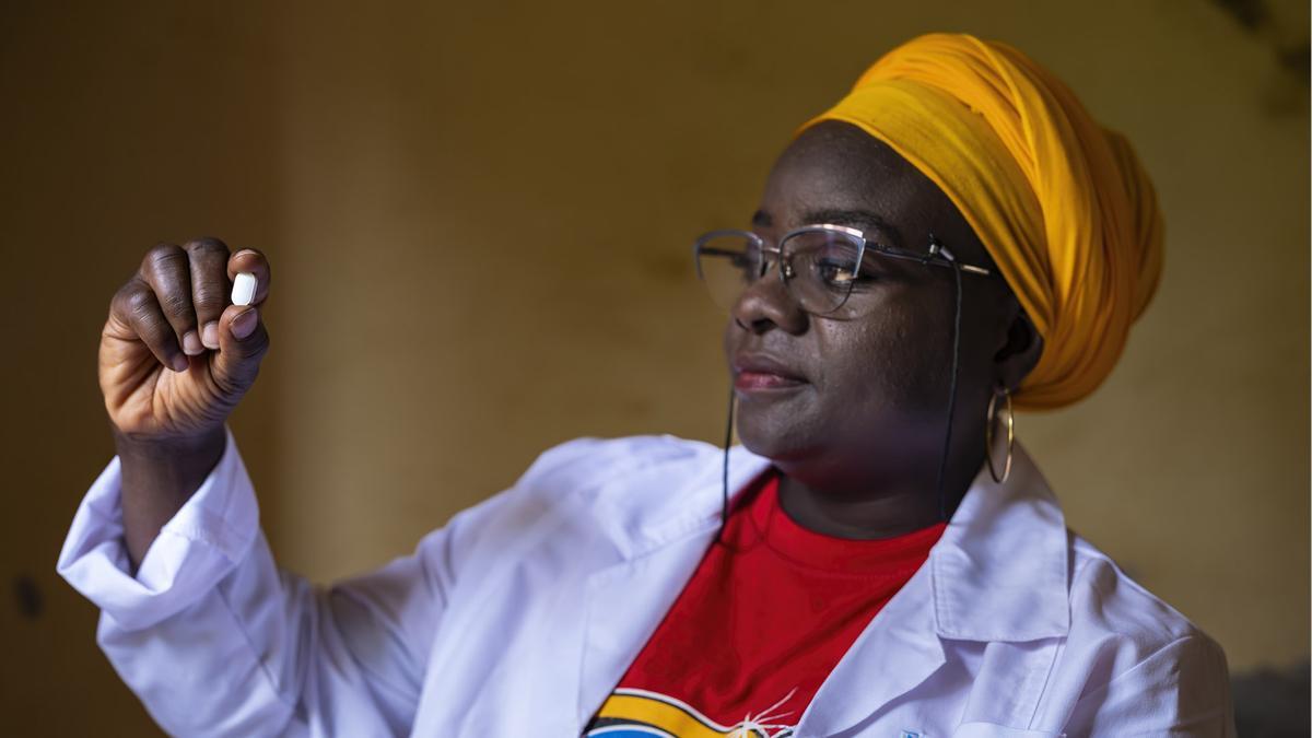 La investigadora del DNDi Mariame Camara, con una píldora de acoziborol contra la enfermedad del sueño, en Guinea.