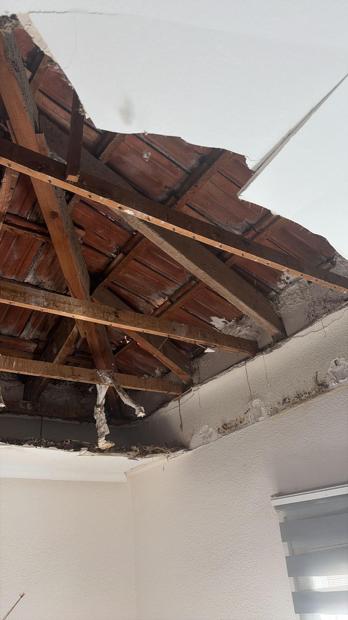 Vista parcial del agujero que ha quedado en el techo de la vivienda siniestrada en Elche